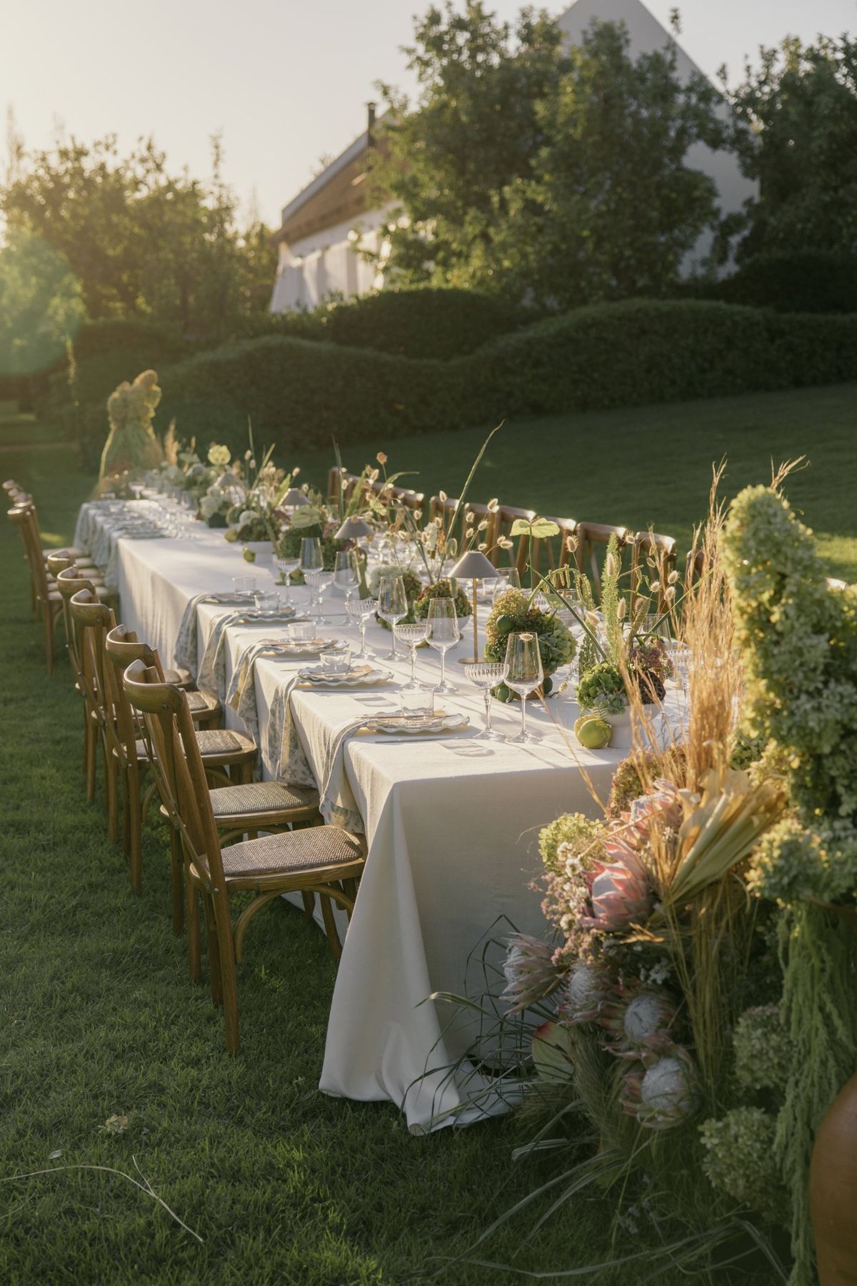 Long garden table styled with florals at golden hour
